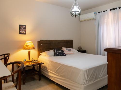ein Schlafzimmer mit einem Bett und einem Tisch mit einer Lampe in der Unterkunft Unidade do térreo: casa à beira mar XJ6722 in São Francisco do Sul
