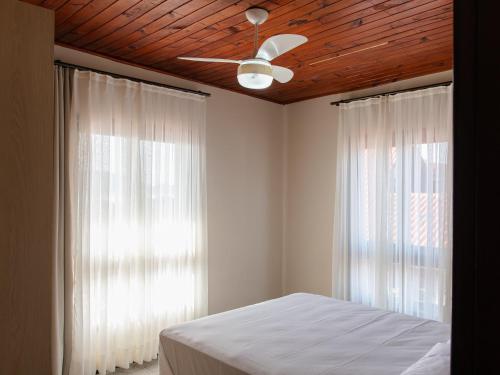 サン・フランシスコ・ド・スルにあるPiso superior:casa aconchegante à beira mar XS7441のベッドルーム1室(天井ファン、窓2つ付)