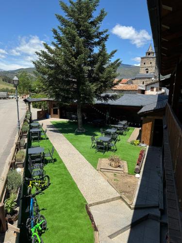 a row of chairs and tables and a tree at Hotel Cal Rei de Talló in Bellver de Cerdanya 