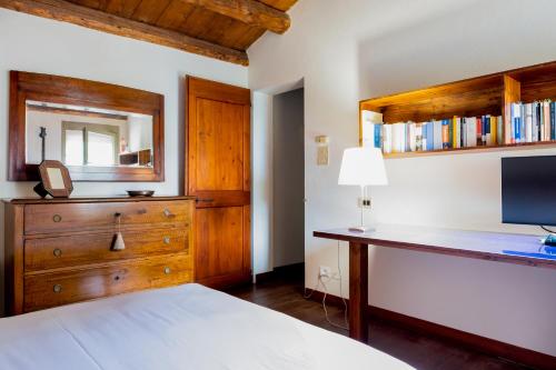a bedroom with a bed and a desk with a mirror at Oasi Dolce Vita in Lozzo Atestino