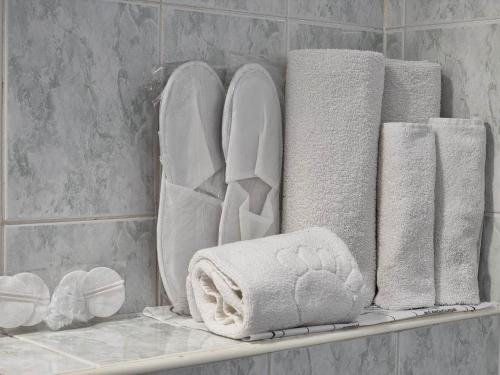 a shelf with towels and towels on it in a bathroom at Jeweller Hotel in Ruse