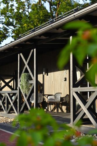 a house with two chairs and a table on the porch at Bahnhofs hotel in Alūksne