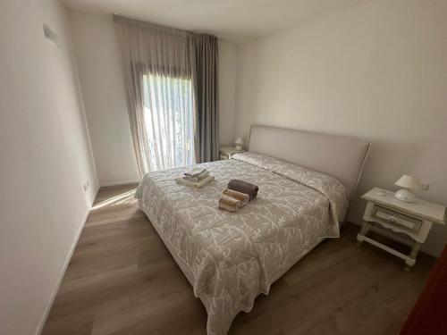 a bedroom with a bed with two towels on it at Belvedere dagli oleandri in Liscia di Vacca