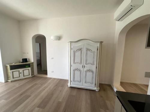 a white door in a room with a wooden floor at Belvedere dagli oleandri in Liscia di Vacca