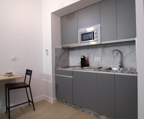 a kitchen with a sink and a microwave at V11apartamentos 2 in Archidona