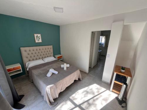 a bedroom with two beds and a green wall at Hospedaje LH Planta baja E a 15 minutos del aeropuerto de Ezeiza in Ezeiza