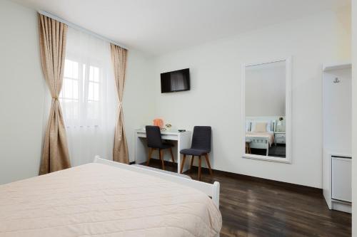 a bedroom with a bed and a desk with two chairs at Green lakes house 2 in Plitvička Jezera