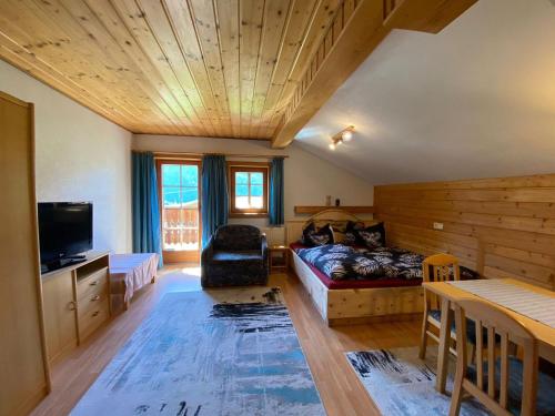 a living room with a couch and a tv at Obenfigerhof in Kals am Großglockner