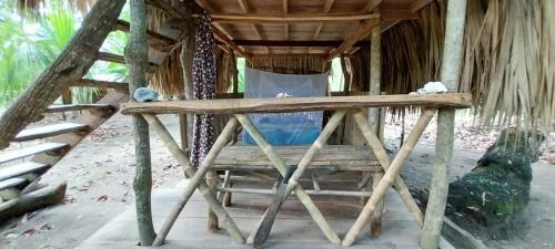 a wooden table in front of a hut on the beach at Eco-Camping Mango Feliz Rincón del Mar in San Onofre