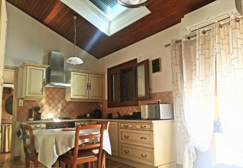 une cuisine avec une table et des chaises et une fenêtre dans l'établissement '' la crossette '' Charmante maison dans quartier calme, à Béziers