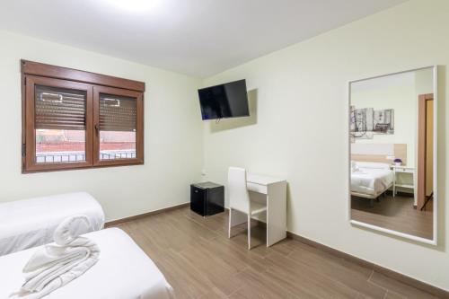 a hotel room with two beds and a mirror at Otero & Elma 2 in Alovera