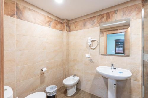 a bathroom with a sink and a toilet and a mirror at Otero & Elma 2 in Alovera