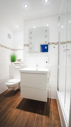 a white bathroom with a sink and a toilet at Hotel König in Remscheid