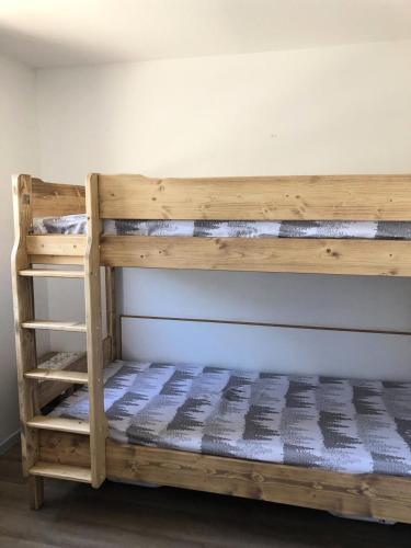 Ce lit superposé en bois se trouve dans un dortoir. dans l'établissement Résidence L'Ours Blanc - maeva Home - Appartement 2 pièces 4 personnes Confort MAE-3444, à Huez