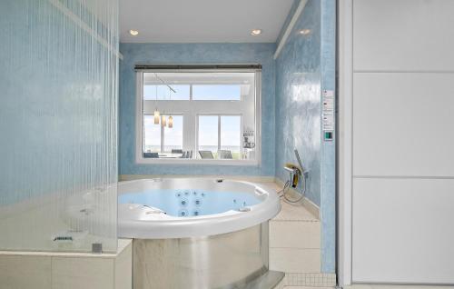 a bath tub in a bathroom with a window at Cozy Home In Kalundborg With Kitchen in Kalundborg