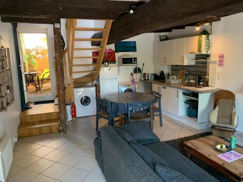 un salon avec un canapé et une table et une cuisine dans l'établissement Le Petit Triskell, Gîtes culturel à la Roche Bernard, Gite les petits bonheurs, à Férel