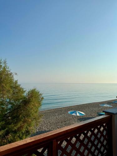 an umbrella sitting on a beach next to the ocean at Betty's Beach House - by the Sea in Kámpos