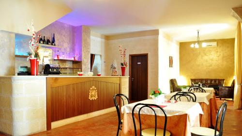 a dining room with two tables and a kitchen at B&B Villa Flora in Santeramo in Colle