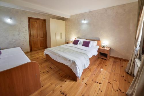 a bedroom with a large bed and a wooden floor at Villa Brda in Petrovac na Moru