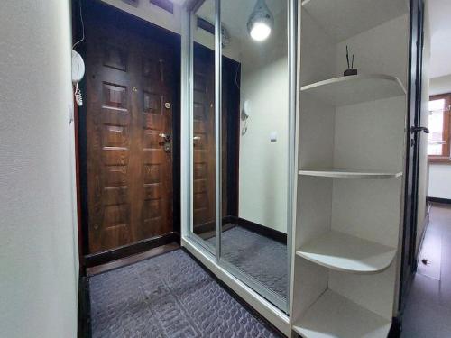 a walkin closet with a glass door and a mirror at Уютная квартира , с удобствами in Taraz