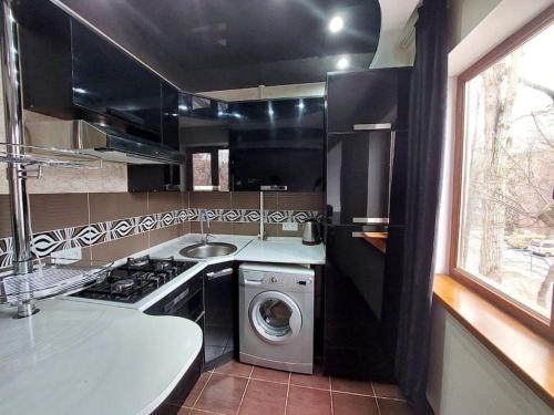 a small kitchen with a washing machine and a sink at Уютная квартира , с удобствами in Taraz