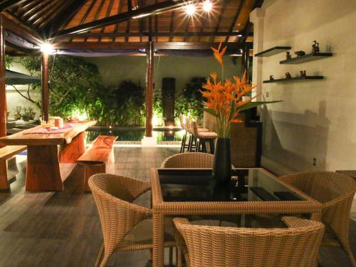 a dining room with chairs and a table with a glass table at Linda Villa Sanur in Sanur