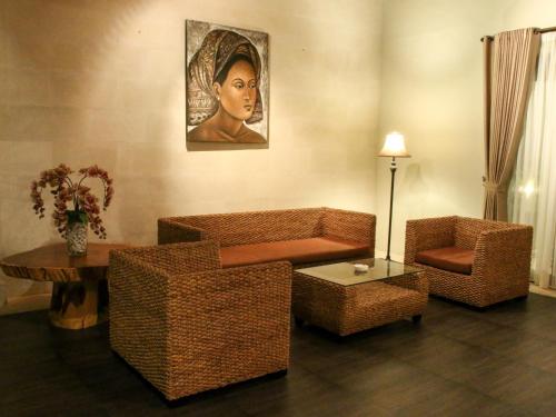 a living room with a couch and a portrait of a woman at Linda Villa Sanur in Sanur