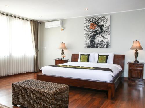 a bedroom with a large bed and a table at Linda Villa Sanur in Sanur