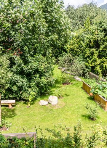 a garden with a bench and trees and grass at Das Viererspitz 1 - Mittenwald in Mittenwald