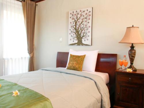 a bedroom with a bed and a lamp at Linda Villa Sanur in Sanur