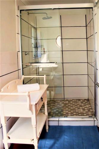 a bathroom with a shower with a tub and a sink at Khayalethu Cottage in Hogsback