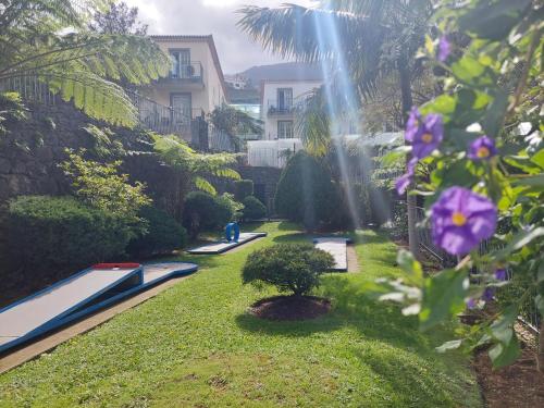 a garden with a swimming pool and a waterfall at Estalagem do Vale in São Vicente