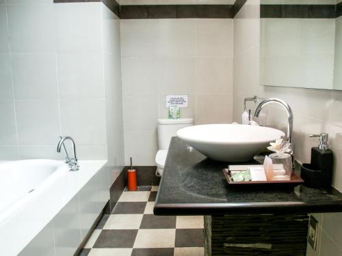 a bathroom with a sink and a toilet and a tub at Linda Villa Sanur in Sanur
