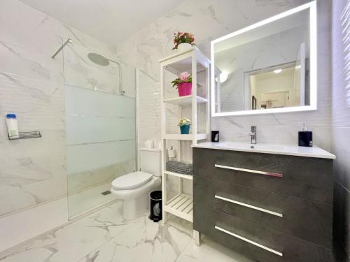 a bathroom with a toilet and a sink and a shower at Ten-Beau Relax Bungalow in Maspalomas