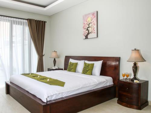 a bedroom with a large bed and a window at Linda Villa Sanur in Sanur