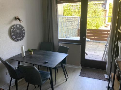 a dining room with a table and chairs and a clock at Time-Out Westerbauer TC15B in Hagen