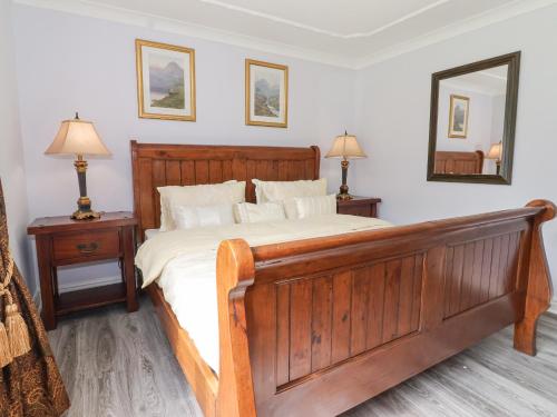 a bedroom with a large wooden bed and a mirror at Annexe in Hull