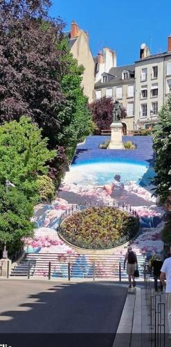 une personne marchant dans une rue à côté d'une fontaine dans l'établissement Gîte du Beauvoir Hyper Centre, à Blois