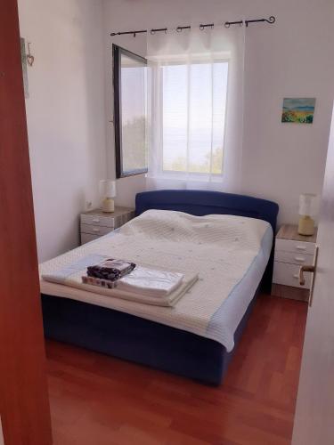 a bedroom with a large bed with a window at Apartments Smokva in Opatija