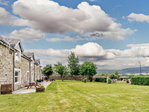 a yard of a stone house with a grass field at InEdra Estate Farmhouse by edradour1725 in Pitlochry