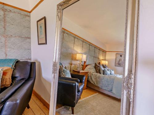 a mirror in a bedroom with a bed and a couch at InEdra Estate Farmhouse by edradour1725 in Pitlochry