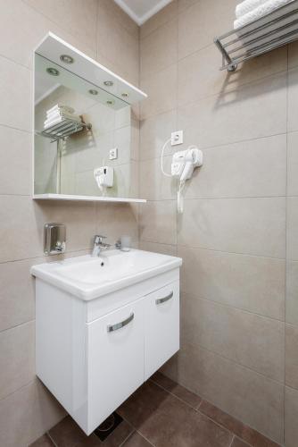 a bathroom with a white sink and a mirror at Green lakes house in Plitvička Jezera