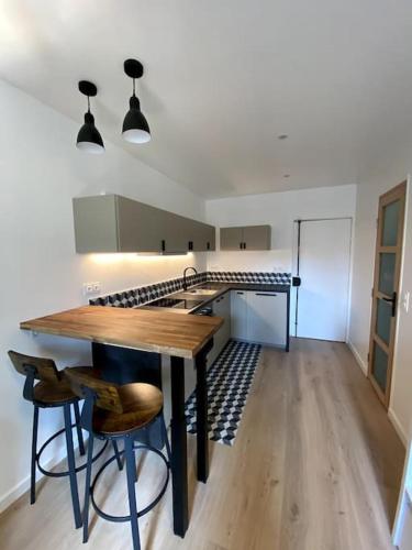 une cuisine avec une table en bois et quelques chaises dans l'établissement Appartement moderne & calme Paris Sacré coeur, à Paris