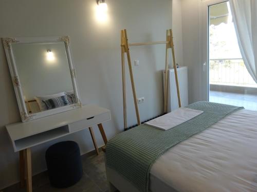 a bedroom with a bed and a mirror on the wall at Palio Seaside Escape in Kavala