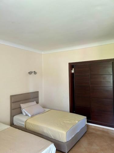 a bedroom with two beds and a closet at Appartement Kabila Vista à 10min à pied de la plage in Marina Smir