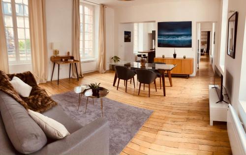 un salon avec un canapé et une table dans l'établissement So Guest- Luxueux appartement, ancienne maison de champagne proche Cathédrale, à Reims
