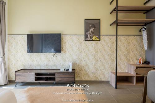 a living room with a television on a wall at Mossaz at Empire Damansara by Wodages in Kuala Selangor