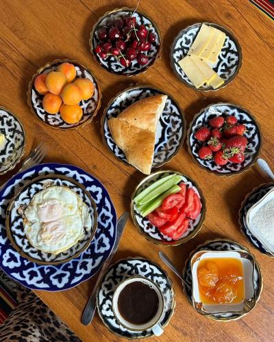 een tafel met borden met voedsel en fruit bij B-House Boutique with Terrace in Bukhara