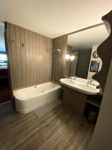 une salle de bain avec une baignoire et un lavabo dans l'établissement Résidence Petaru - Spacieux duplex pour 4 personnes situé à Méribel centre proche des commerces MAE-2143, à Les Allues