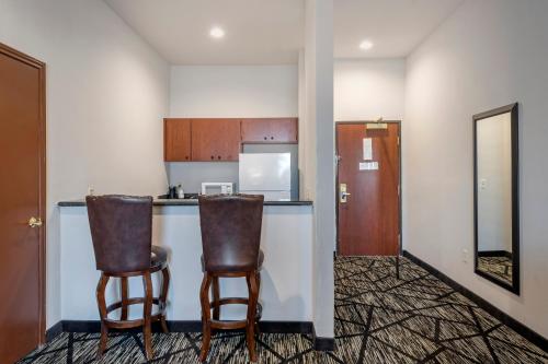 a kitchen with two bar chairs and a counter at Best Western Plus McKinney Inn and Suites in McKinney